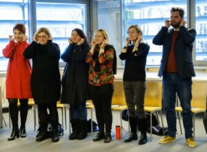 Sześcioro uczestników wykonuje ćwiczenia rozgrzewkowe.