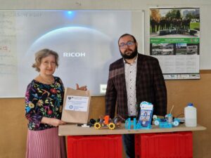 Zdjęcie przedstawia prezentera oraz uczestnika warsztatów oraz zestaw edukacyjny wodorowy