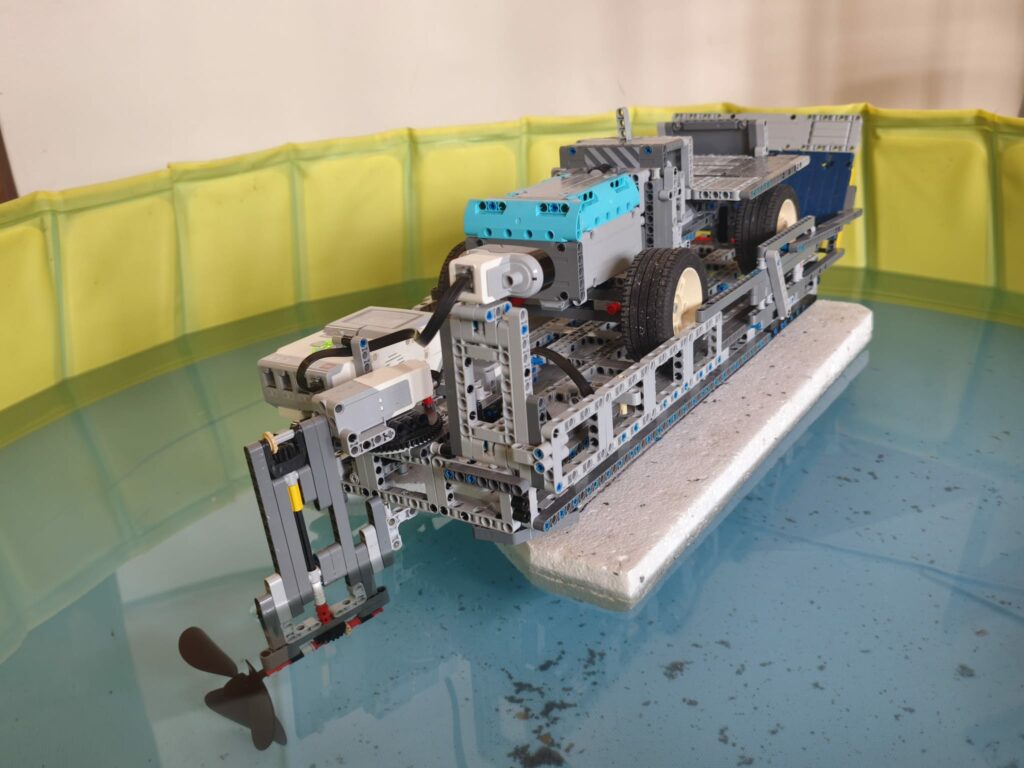 Model łódki zbudowany z klocków lego unosi się na wodzie i dwa zdjęcia, których miniaturek nie widać. Kliknięcie powoduje zwiększenie zdjęcia.