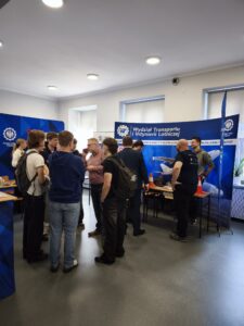 Stanowisko Wydziału Transportu i Inżynierii Lotniczej, dookoła stoją uczestnicy i organizatorzy wydarzenia. Kliknięcie powoduje zwiększenie zdjęcia.