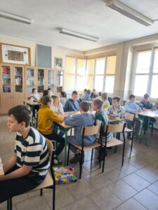 Dzieci siedzą przy stołach i grają w różne gry planszowe . Kliknięcie powoduje zwiększenie zdjęcia.