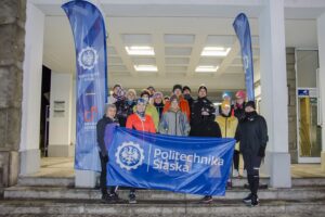 Uczestnicy grupy biegowo-chodziarskiej z flagą Politechniki Śląskiej