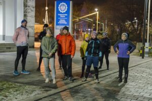 Grupa biegaczy przed rektoratem, w tle plac Krakowski oraz pylon Politechniki