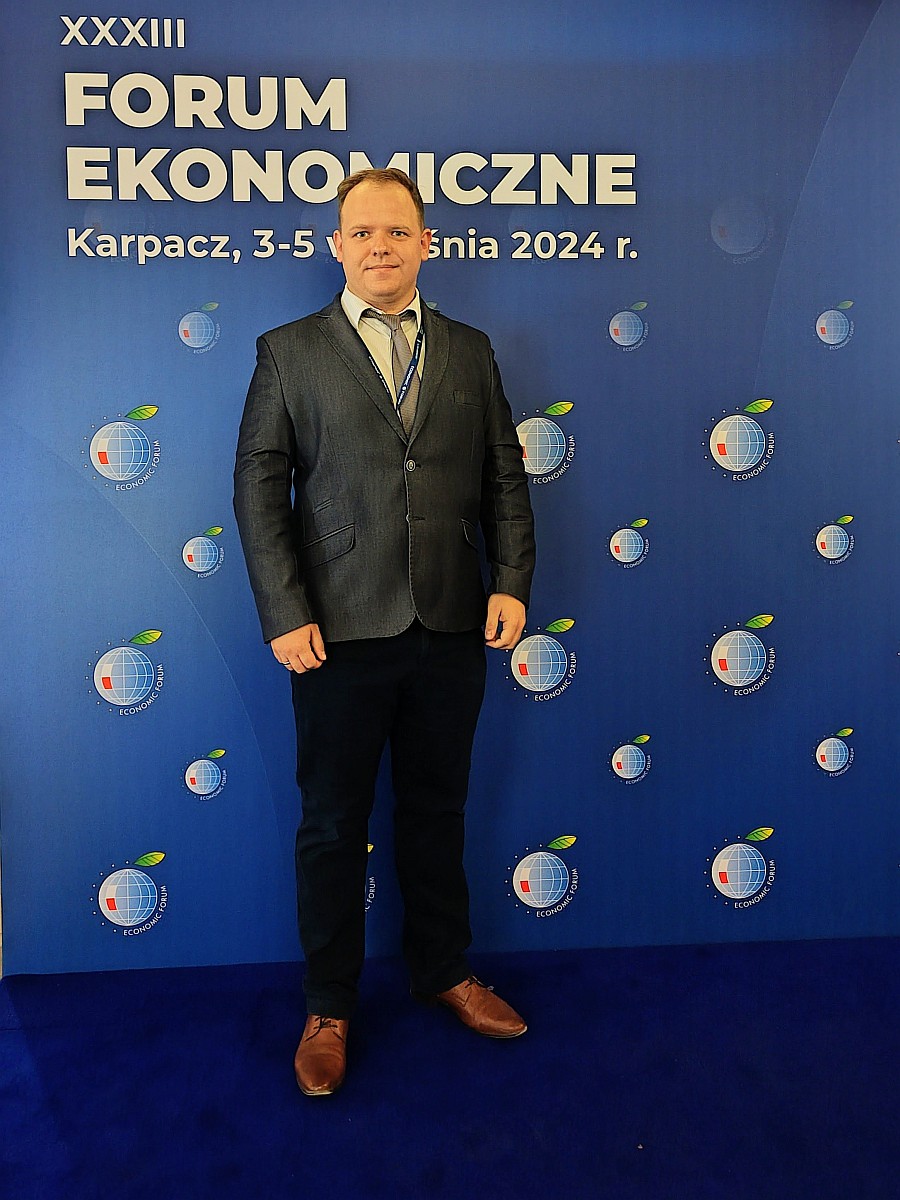 Krzysztof Krawiec na tle ścianki z napisem Forum Ekonomiczne