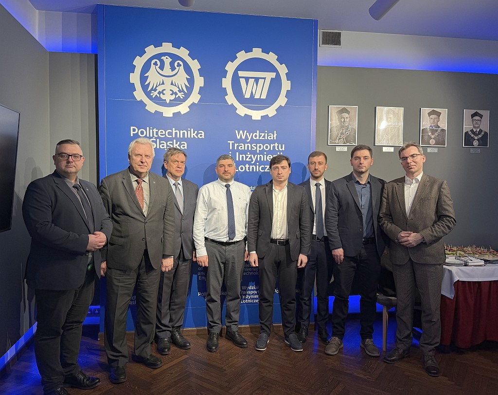 uczestnicy spotkania pozują na tle ścianki wydziałowej