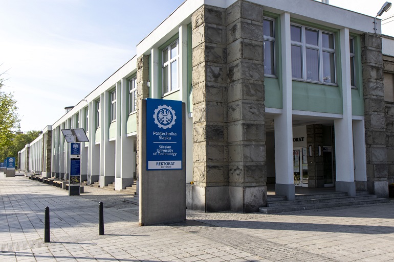 Na zdjęciu widzimy budynek Rekotratu przed którym stoi niebieski totem z logo Politechniki