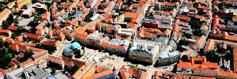 Na zdjęciu widzimy stare miasto z lotu ptaka. Są to kamienice a w środku rynek z małym kościółkiem z niebieskim dachem