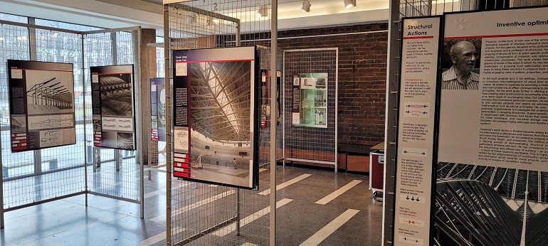 Na zdjęciu widzimy wystawę zdjęć twórczości Wacława Zalewskiego. Wystawa stoi w holu, zdjęcia umieszczone na metalowych stojakach