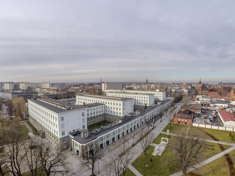 Na zdjęciu widzimy zdjęcie kampusu z lotu ptaka. Widać biało szare budynki rektoratu oraz wydziału górnictwa