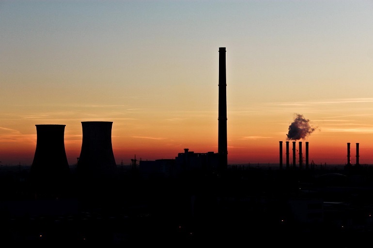 Na zdjęciu widzimy elektrownię węglową na tle zachodzącego słońca