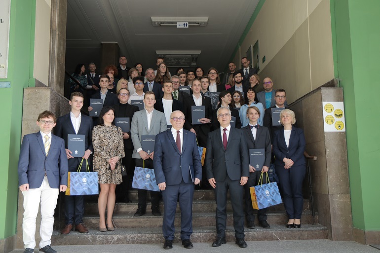 Na zdjęciu widzimy wszystkich laureatów konkursu i Rektora i Prorektora stojących na schodach