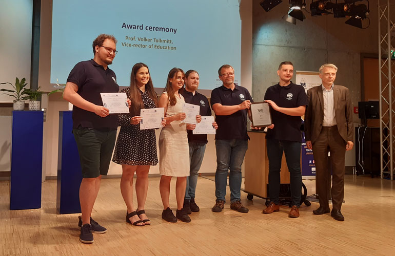Zdjęcie przedstawia kilkuosobową grupę nagrodzonych studentów.