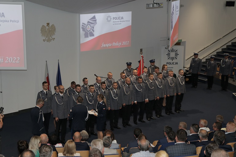 Na zdjęciu widzimy policjantów otrzymujących nominacje. Stoją w szeregu , na baczność.