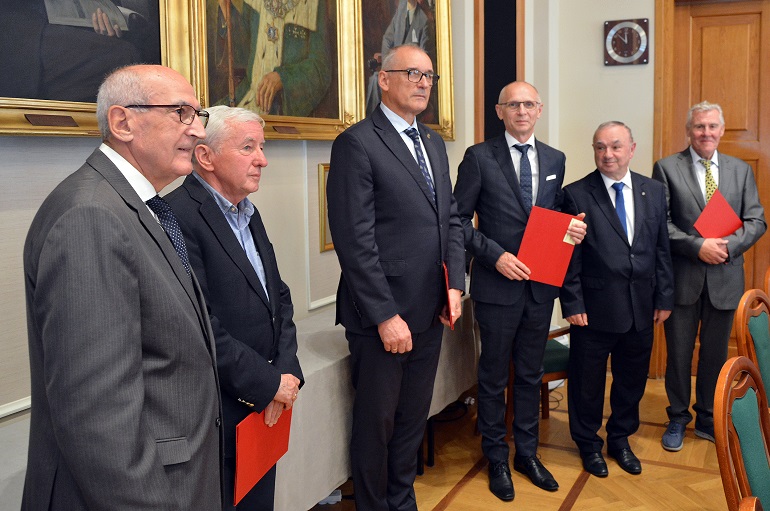 Na zdjęciu widzimy kilku członków zgromadzenia stojących i pozujących do zdjęcia w Sali