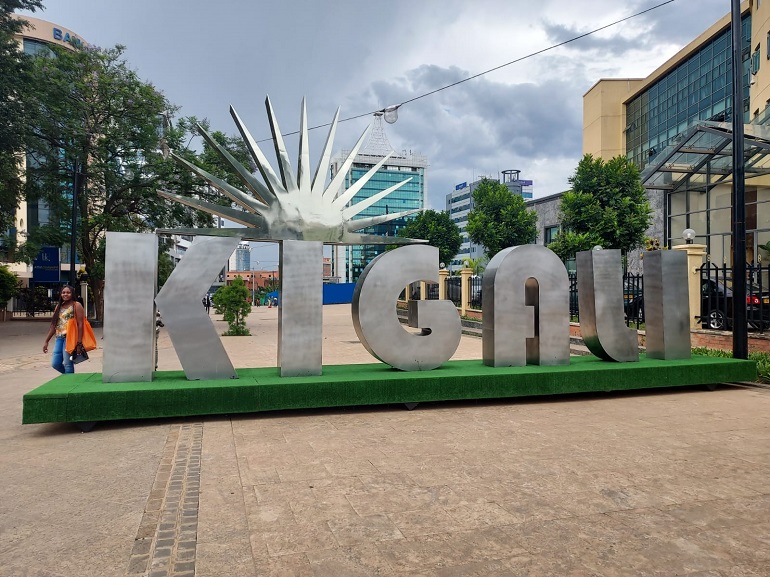Na zdjęciu widzimy duże srebrne litery układające się w słowo KIGALI. Litery te stoją na ulicznym placu