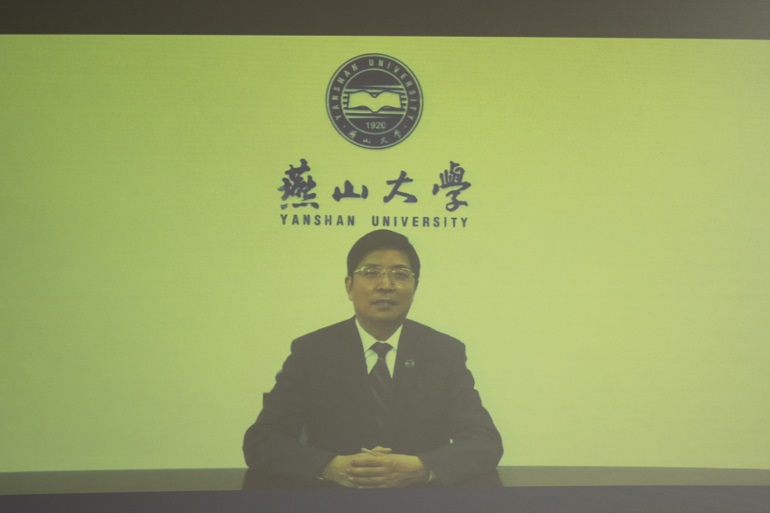 Na zdjęciu widzimy rektora Uniwersytetu Yanshan, który przemawia na wyświetlanym filmie