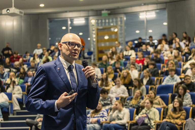 Na zdjęciu widzimy wykładowcę prowadzącego wykład podczas imprezy