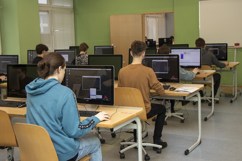 Na zdjęciu widzimy uczestników Olimpiady przy komputerach rozwiązujących zadania informatyczne