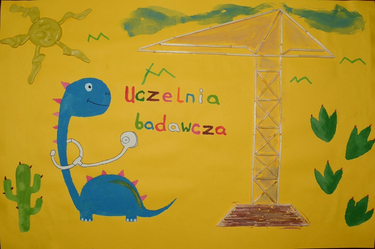 Na zdjęciu widzimy prace konkursowa przedstawiającą dinozaura na złotym tle i napis uczelnia badawcza