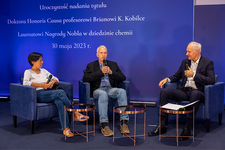 Na zdjęciu widać prof. B. Kobilkę z żoną i prof. Marka Pawełczyka na scenie