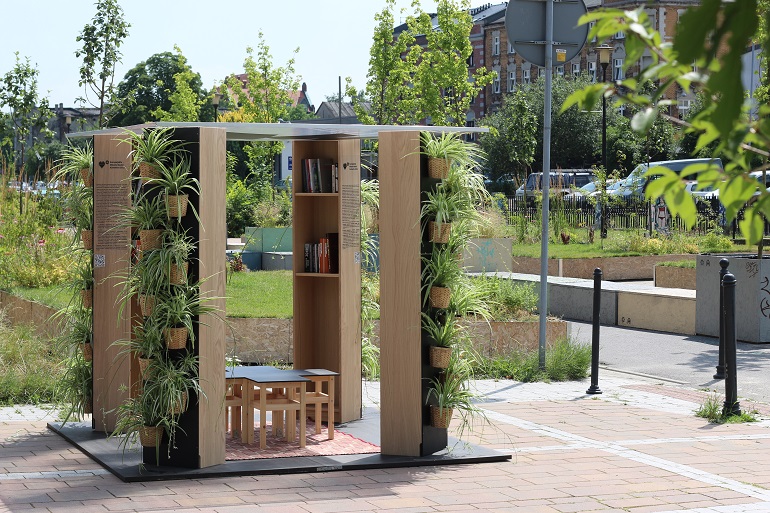 Na zdjęciu widzimy Bibliotekę plenerową. To mała drewniana altana wewnątrz której sa książki a na zewnątrz rosną kwiaty