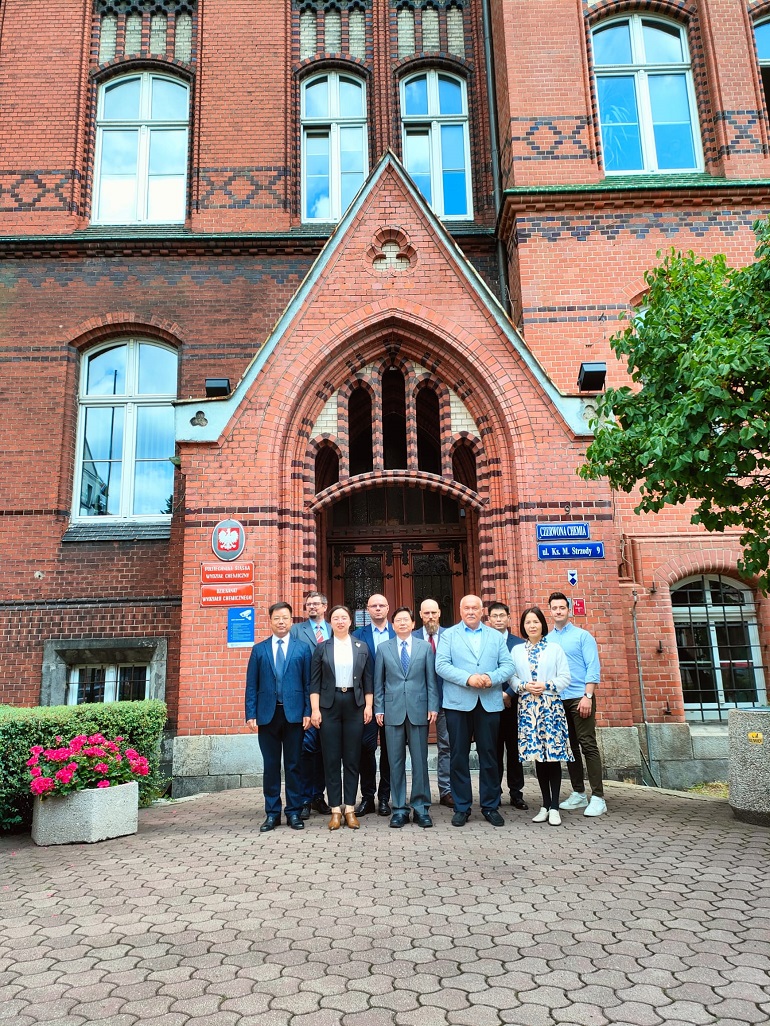 Na zdjęciu widzimy delegację chińska z władzami uczelni na tle ceglanego budynku Wydziału Chemii