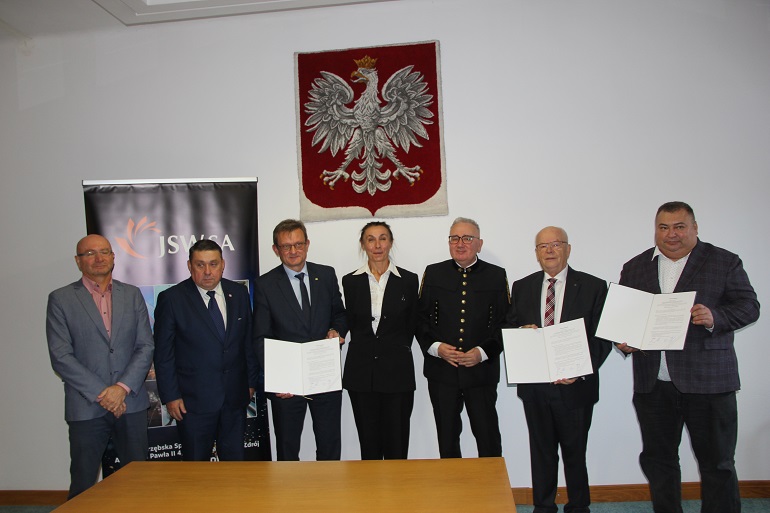 na zdjęciu kilku uczestników podpisana umowy. Stoją i pozują do zdjęcia