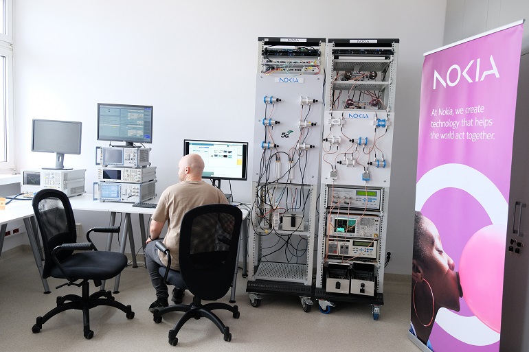 Na zdjęciu laboratorium i przy komputerze siedzi mężczyzna