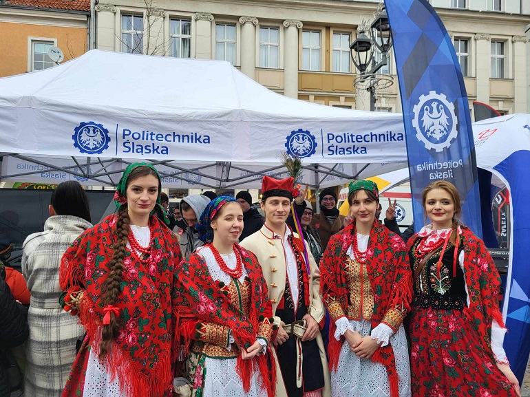 na zdjęciu AZT Dąbrowiacy w strojach ludowych na tle stoiska Politechniki Śląskiej