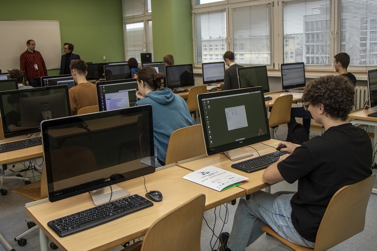 Na zdjęciu widzimy uczniów siedzących przed monitorem komputera
