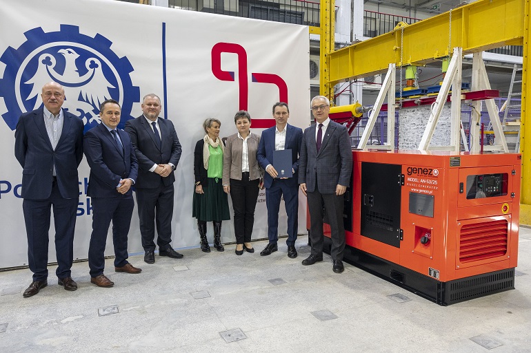 na zdjęciu uczestnicy spotkania przy generatorze prądu