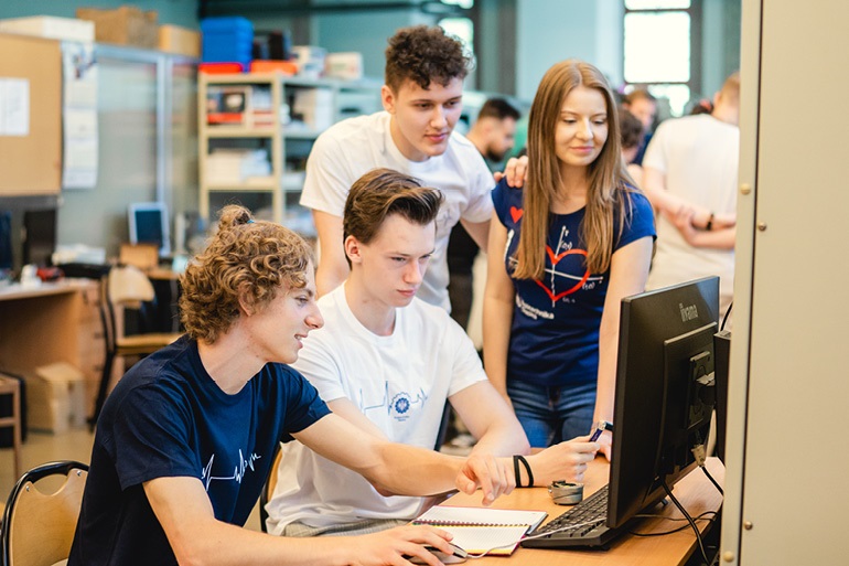 studenci siedzący na sali wykładowej przy komputerze