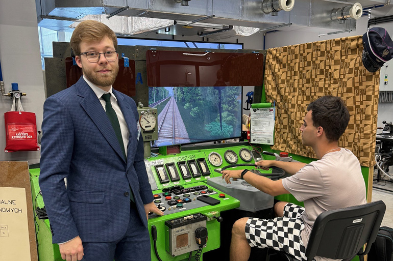 na zdjęciu dwójka studentów przy symulatorze kolejowym