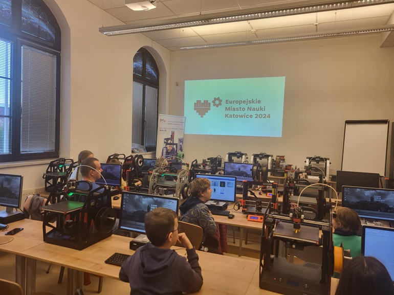 na zdjęciu sala z drukarkami 3D i uczestnicy warsztatów