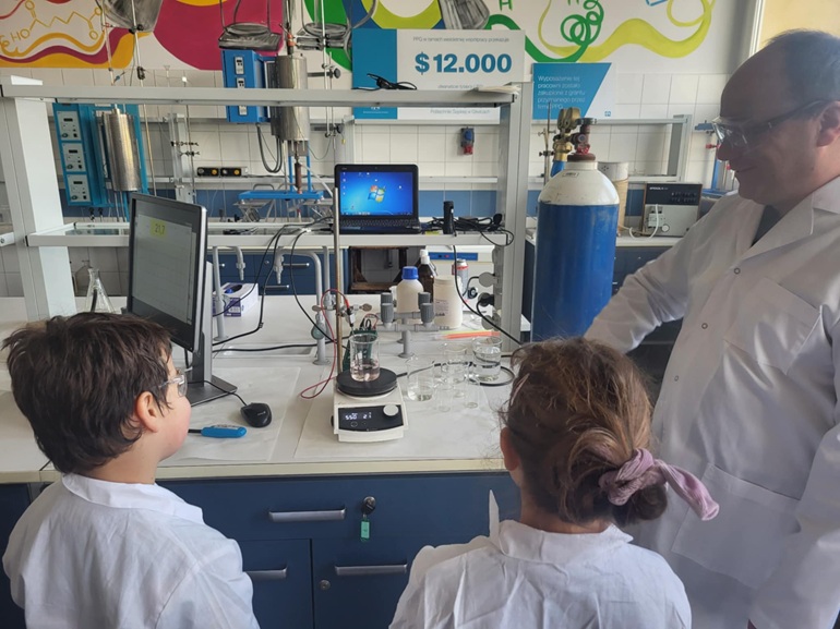Na zdjęciu laboratorium dwójka dzieci i naukowiec