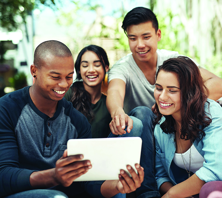 Shot of a group of young men and women using a digital tablet together on campus