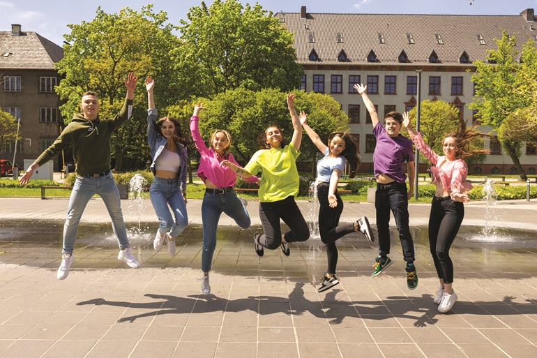 na zdjęciu grupa studentów na terenie kampusu