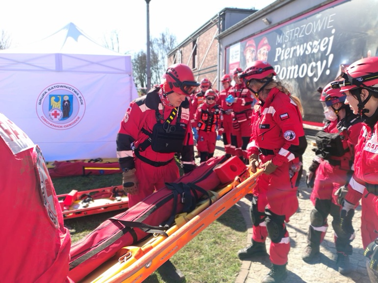 na zdjeciu ratownicy w czerwonych kombinezonach