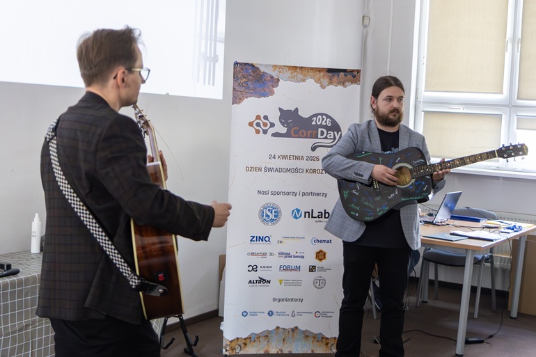 dwaj naukowcy grają na gitarach