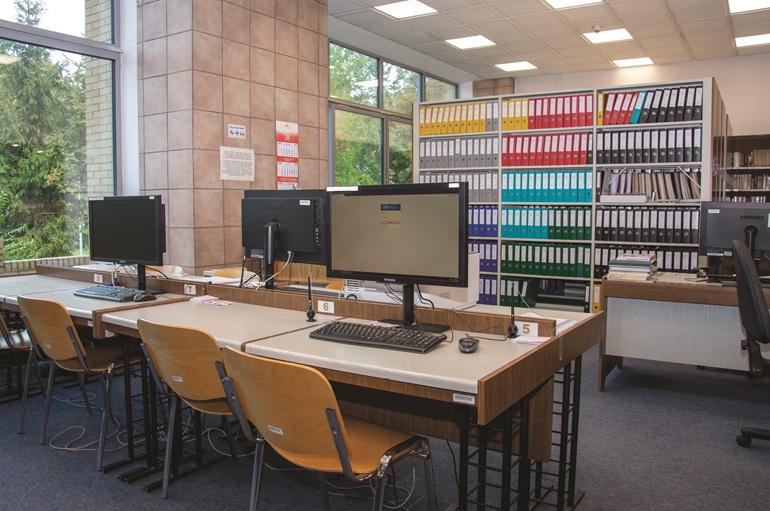 na zdjęciu pomieszczenie biblioteczne ze stanowiskiem komputerowym