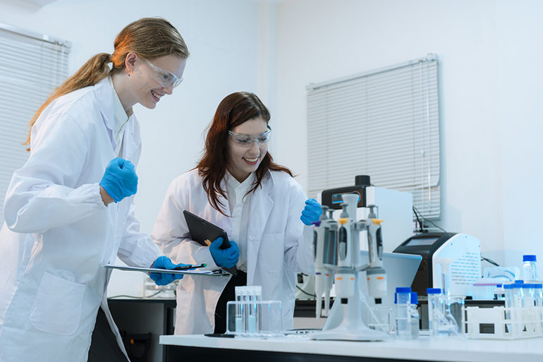 Successful chemist scientist or doctor giving victory thumbs up to show success and motivation.