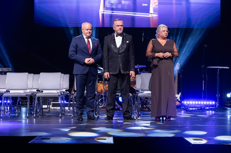 na zdjęciu scena na której stoi dwóch mężczyzn i kobieta