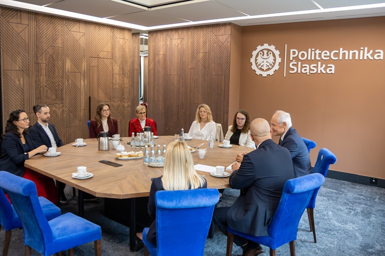 na zdjęciu widzimy stypendystów siedzących przy stole wspólnie z rektorami biorącymi udział w uroczystości